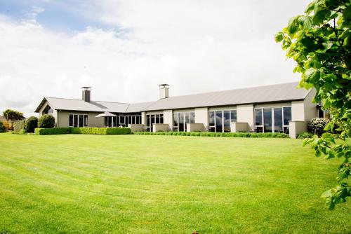 an exterior view of a building with a large lawn at Dunluce Boutique B&B in Te Anau