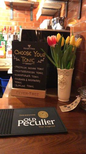 a sign and a vase of tulips on a counter at The Bay Horse, Masham in Masham