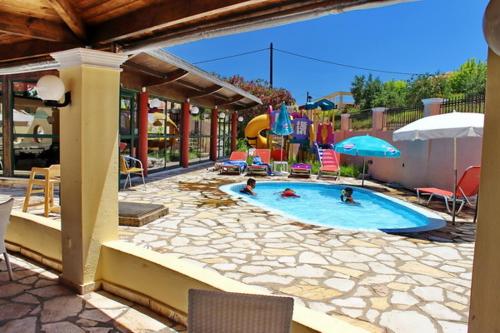 a swimming pool with two people in it at Mediterranean Blue in Kavos