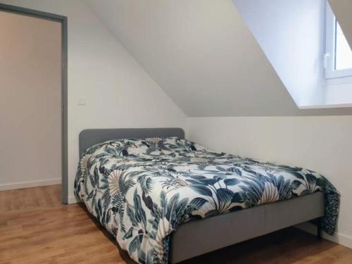 ein Schlafzimmer mit einem Bett mit einer blauen und weißen Decke in der Unterkunft Agréable Maison de 72m2, avec terrasse privée in Boeil-Bezing