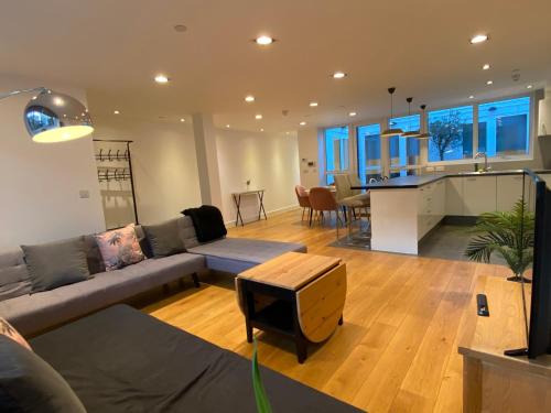 ein Wohnzimmer mit einem Sofa und einem Tisch in der Unterkunft Bright, spacious, 3-bedroom Emirates apartment with terrace in London