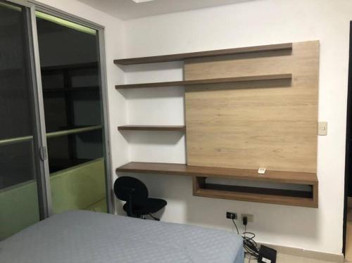 a bedroom with a bed and a wall with shelves at 2 room department (5 people). Private exclusive area in Guayaquil in Guayaquil