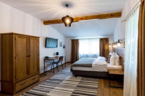 a bedroom with a bed and a table in it at Drachenhaus Urban Villa in Braşov