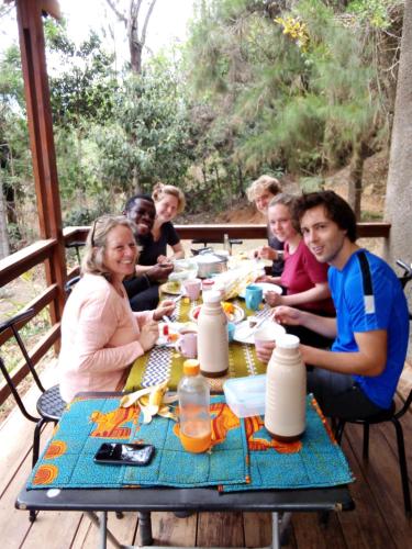 Un groupe de personnes assises à une table en train de manger dans l'établissement Lushoto Pazuri, à Makungulu