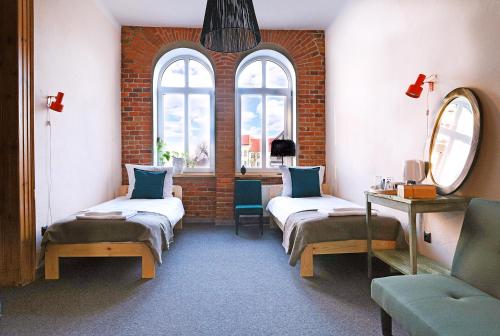 Pokój z 2 łóżkami i stołem oraz 2 oknami w obiekcie 5 Porte w mieście Racibórz
