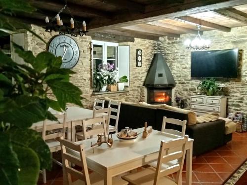 A Casa das Augas في موندينيدو: غرفة معيشة مع طاولة وكراسي ومدفأة