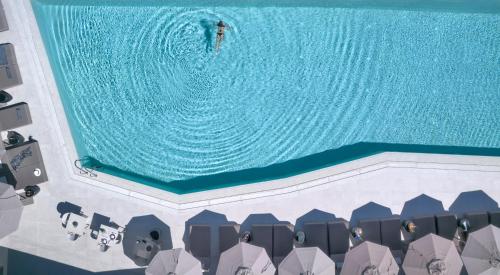 a man riding a wave in a swimming pool at Aeonic Suites and Spa in Mýkonos City