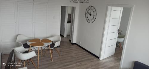 een kamer met een tafel en stoelen en een klok bij KLIF 1 Apartamenty-Warka in Warka