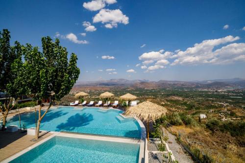 a swimming pool with umbrellas and a view of a city at KingsResidenceVilla in Nafplio