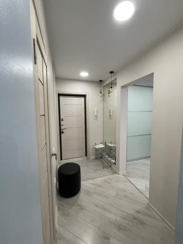 a hallway with a door and a stool in a room at Krivenko 49 Str by StayInn in Pavlodar
