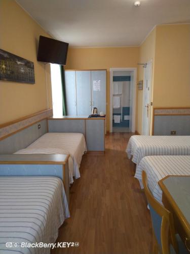 a room with three beds and a tv on the wall at Hotel Route 9 in Cadeo