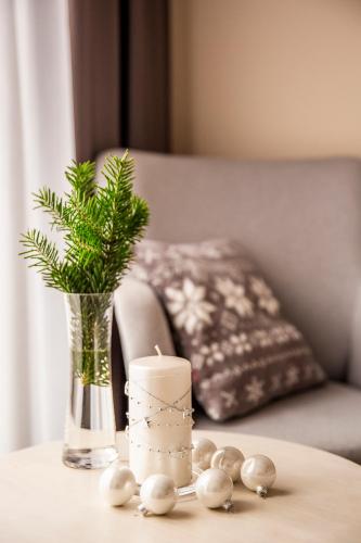 a table with a candle and a vase with a plant at Apartament Bimba & Free Parking in Poznań