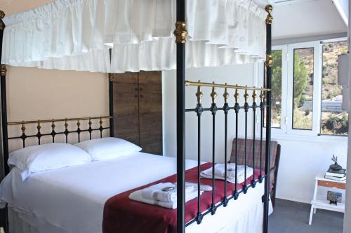 Schlafzimmer mit Himmelbett und weißer Bettwäsche in der Unterkunft Laoni Guest House in Moutoullas, Marathasa in Limassol