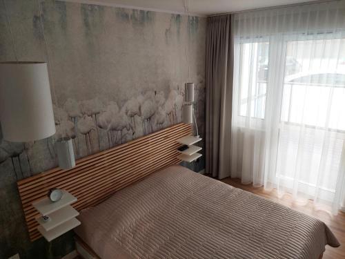 a bedroom with a bed and a large window at Apartament na Kasprowicza in Kołobrzeg