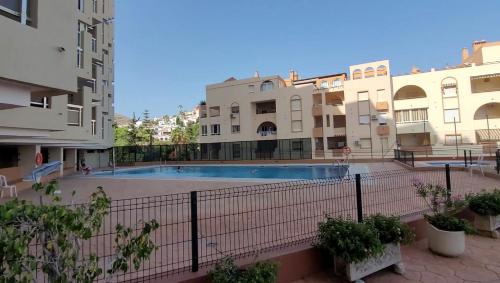 a swimming pool in the middle of some buildings at Chinasol Suites in Almuñécar