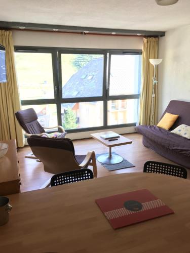 un salon avec une table, des chaises et un canapé dans l'établissement La Mongie, apt 30m2 centre station, à Bagnères-de-Bigorre