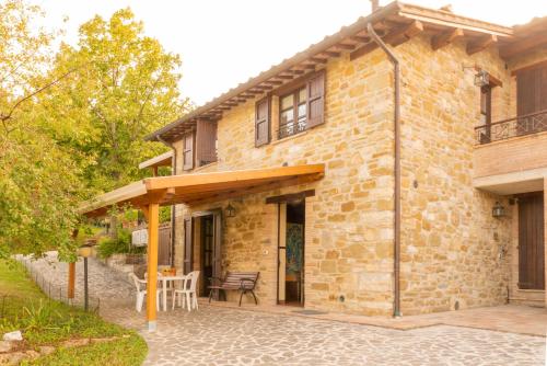 a stone house with a patio in front of it at Fonte Chiara in Gubbio