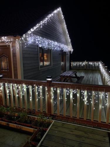 a house with christmas lights on the front porch at Riverside Chalet Borve Isle of Lewis in Borve