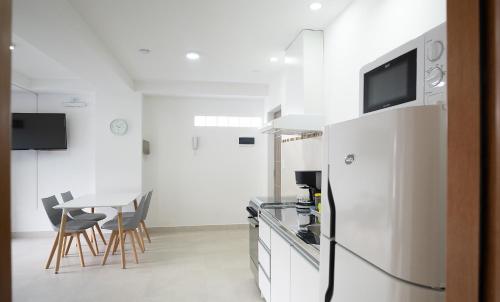 a kitchen with a white refrigerator and a table at Happy Guest Apart 56 in Ushuaia