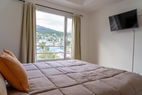 a bedroom with a bed and a large window at Happy Guest Apart 56 in Ushuaia
