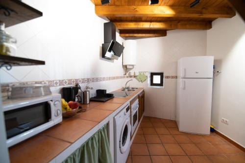 a kitchen with a white refrigerator and a sink at El Postigo in Trujillo