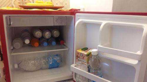 an open refrigerator filled with drinks and food at Habitación en casa con pileta en Río Ceballos in Río Ceballos