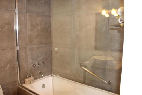 a bathroom with a shower and a bath tub with a glass door at Union Hotel Cusco in Cusco