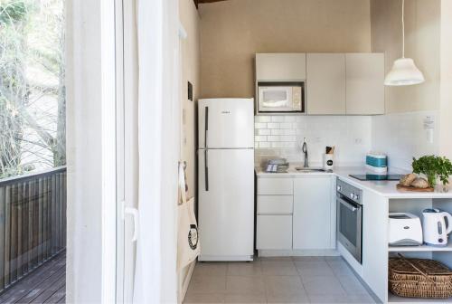 a kitchen with white appliances and a white refrigerator at Plenilunio Mar de las Pampas in Mar de las Pampas