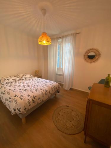 1 dormitorio con cama y lámpara de araña en Gîte en RDC 72m2 - 2 chbres - Box Vélos - Parking, en Bourg-Saint-Andéol