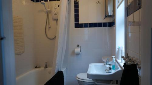 y baño con lavabo, aseo y bañera. en Little Oak Seafront House Donaghadee w/ Seaviews, en Donaghadee