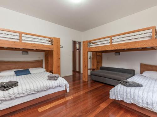 a bedroom with two bunk beds and a couch at Dux Nutz in Smiths Lake