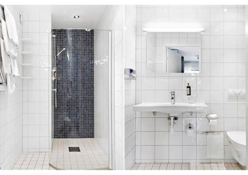 a white bathroom with a shower and a sink at Avanti Apartment Hotel in Stockholm