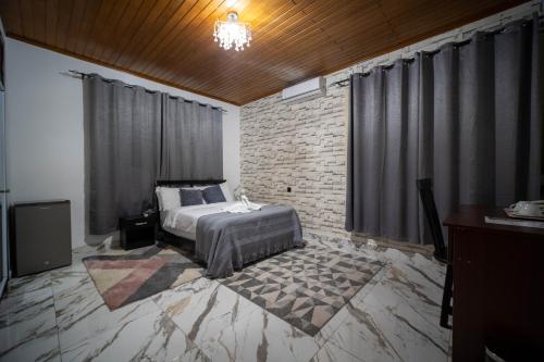 een slaapkamer met een bed en een bakstenen muur bij The Cabyn in Accra