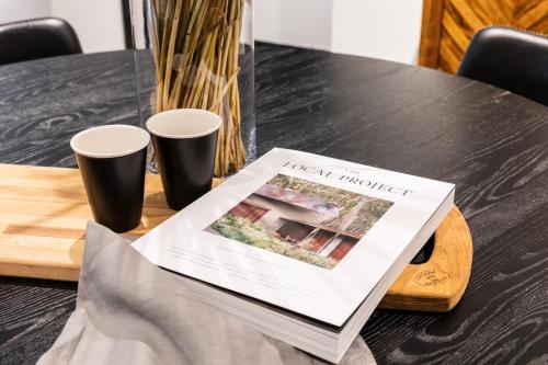 a table with two cups and a newspaper on it at Camden Apartment in Camden