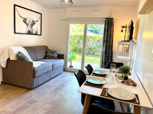 un salon avec un canapé et une table dans l'établissement Perle Marine au pied de la plage, à Cabourg