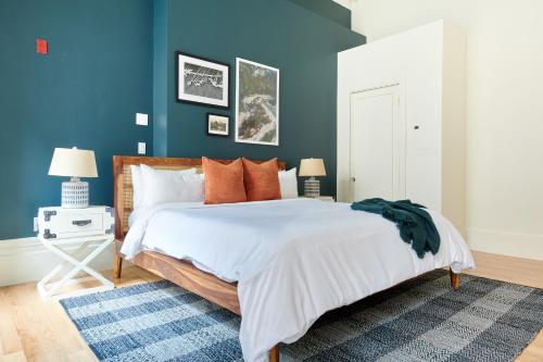 Schlafzimmer mit blauen Wänden und einem Bett mit orangefarbenen Kissen in der Unterkunft Sonder The Hancock in Boston
