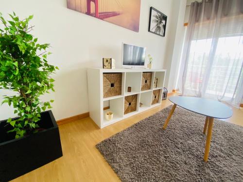 a living room with a table and a potted plant at Apartamento Coselhas 2 in Coimbra