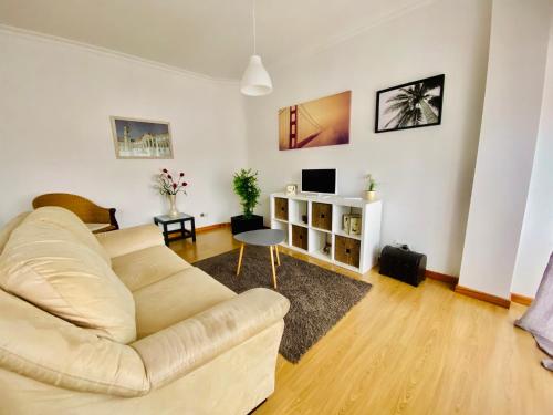 a living room with a couch and a table at Apartamento Coselhas Coimbra in Coimbra
