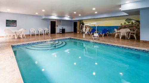 una piscina en un hotel con sillas y mesas en Best Western Classic Inn, en Richmond