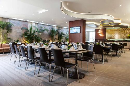 um restaurante com mesas e cadeiras num quarto em Best Western Plus 93 Park Hotel em Bogotá