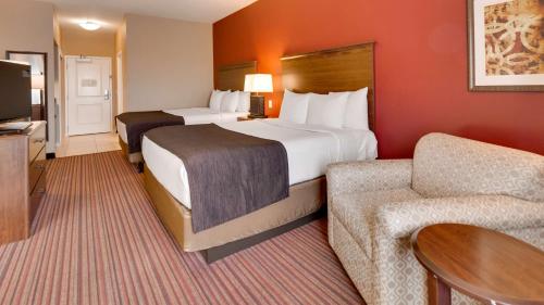 チャンドラーにあるBest Western Plus Chandler Hotel & Suitesのベッド2台とソファが備わるホテルルームです。