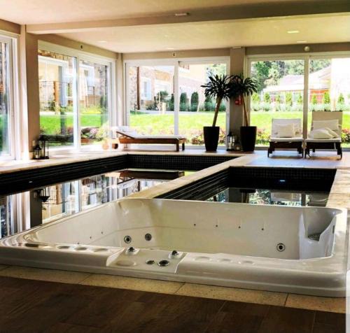 a large living room with a large bath tub at Apartamento em Gramado com piscina in Gramado