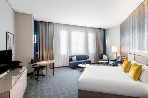 a hotel room with a large bed and a living room at Paradox Sydney in Sydney
