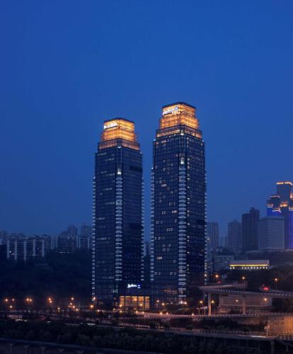 two tall skyscrapers in a city at night at Radisson Blu Plaza Chongqing - Free one cup of smoky the gelnlivet during stay in Chongqing