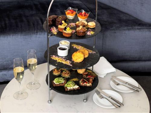 a table with three tiers of appetizers and glasses of wine at Paradox Sydney in Sydney