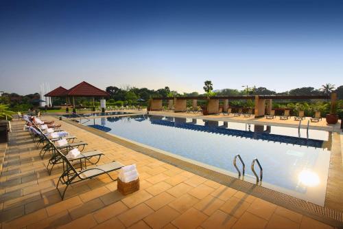 a large swimming pool with lounge chairs next to it at Radisson Blu Dhaka Water Garden in Dhaka