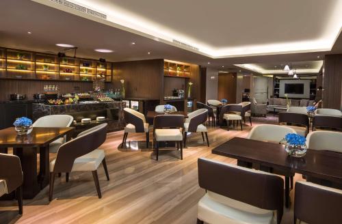 a restaurant with tables and chairs and a bar at Radisson Blu Shanghai Pudong Jinqiao in Shanghai