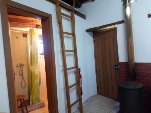 a room with a ladder leading to a door at Casa do Pastor in Lousã