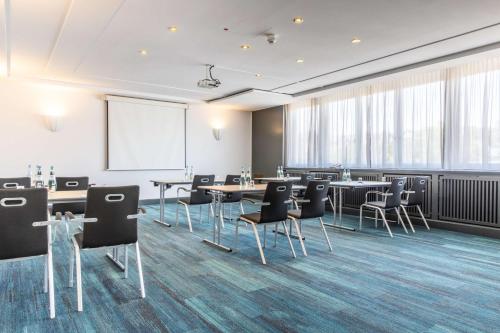 a conference room with tables and chairs and a whiteboard at Radisson Blu Hotel Schwarzer Bock Wiesbaden in Wiesbaden