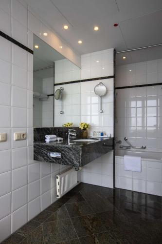 a bathroom with a sink and a mirror at Radisson Blu Hotel Schwarzer Bock Wiesbaden in Wiesbaden